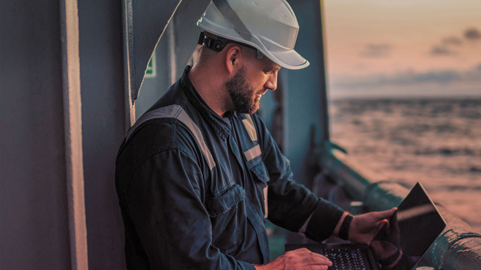 Worker on ship with laptop