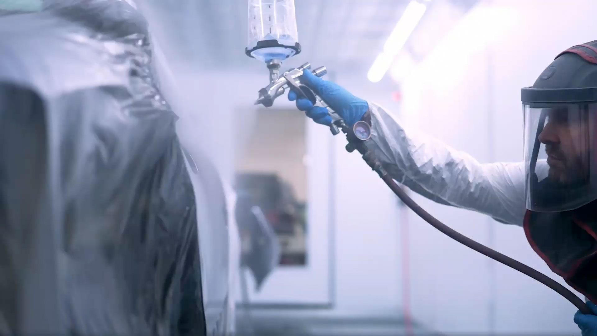 Worker re-spraying a car