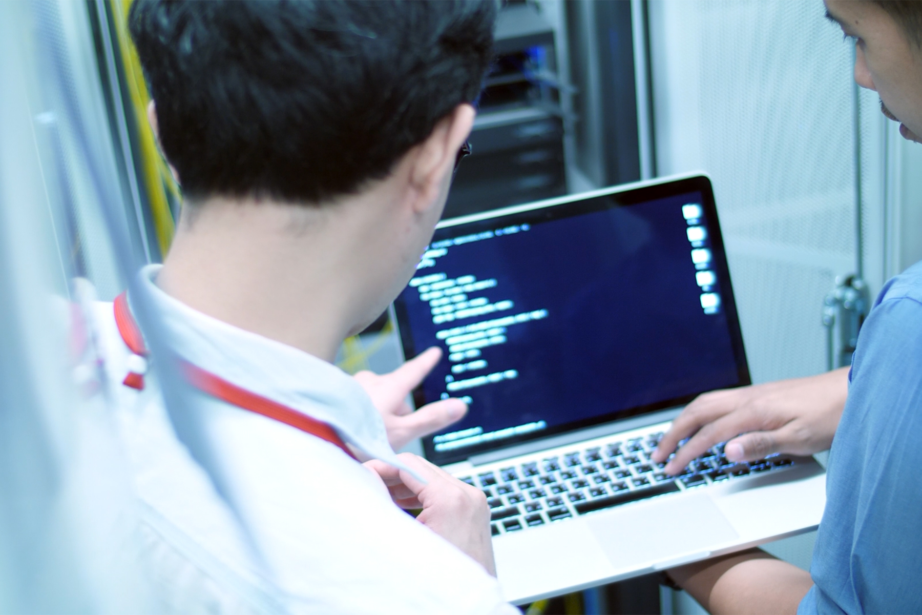 People troubleshooting on computer in server room