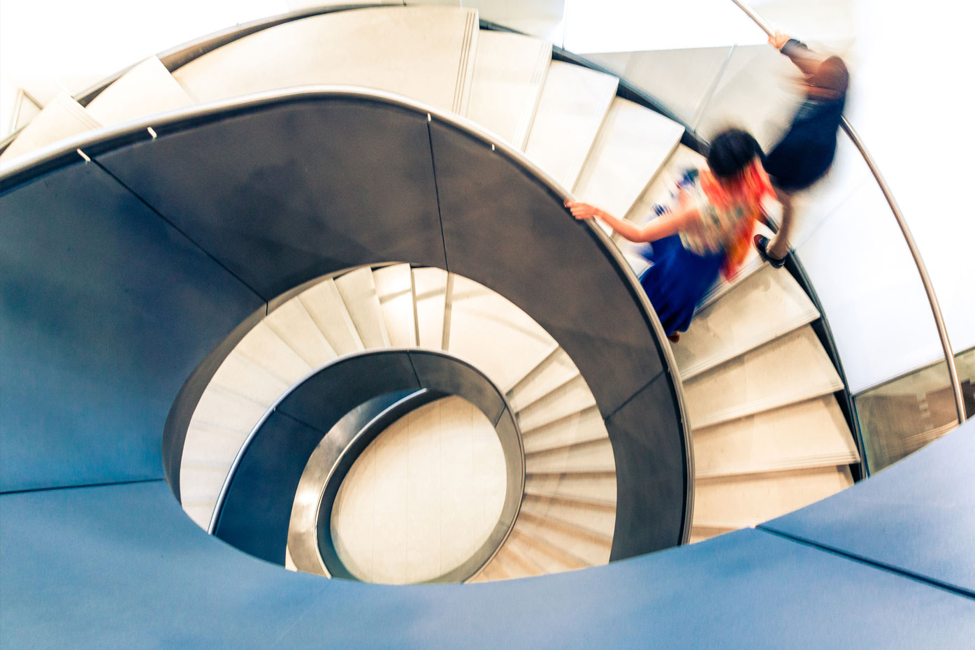 Motion Blur of People on Abstract Spiral Staircase