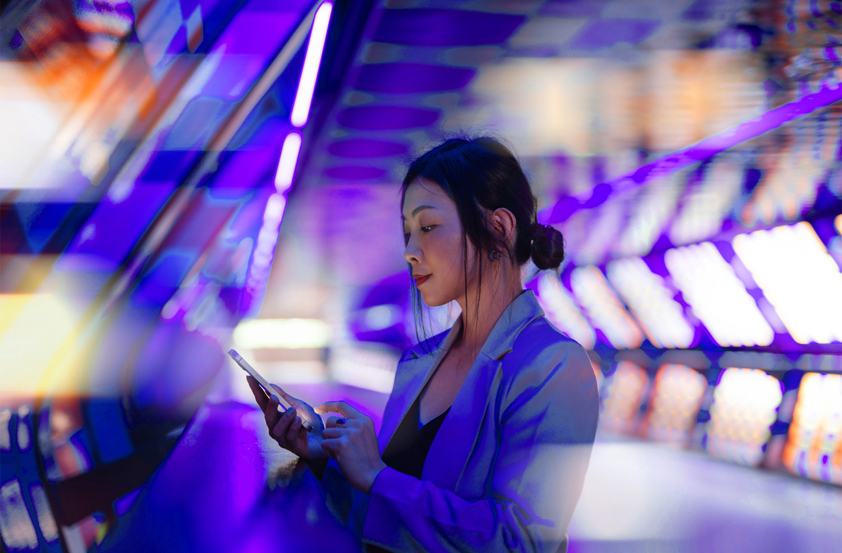 Young business woman holding smartphone with a computer generated background. Innovation, metaverse and futuristic concepts.